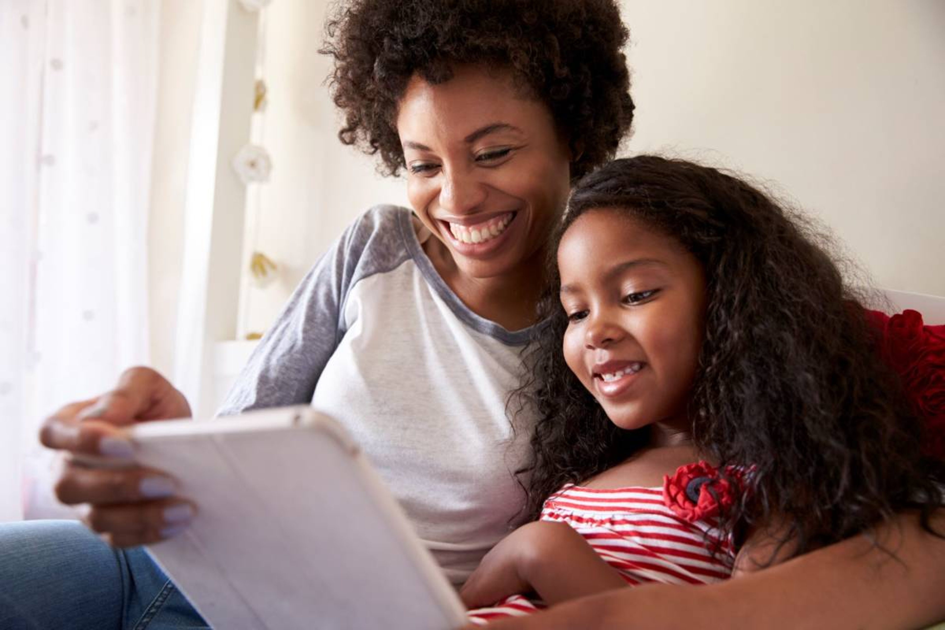 mother and daughter looking at photos on a tablet