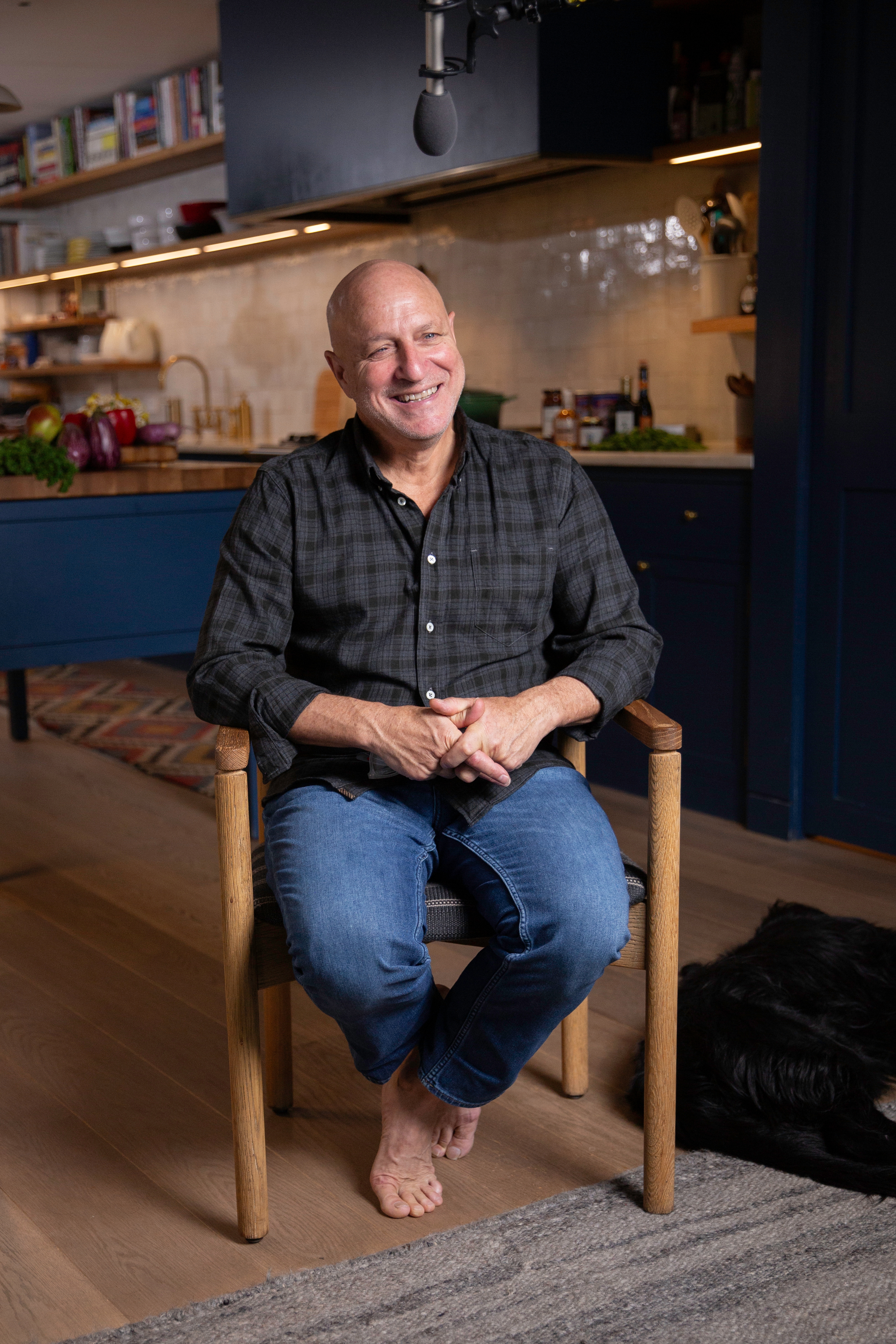 Tom Colicchio sitting in a chair smiling at the camera.