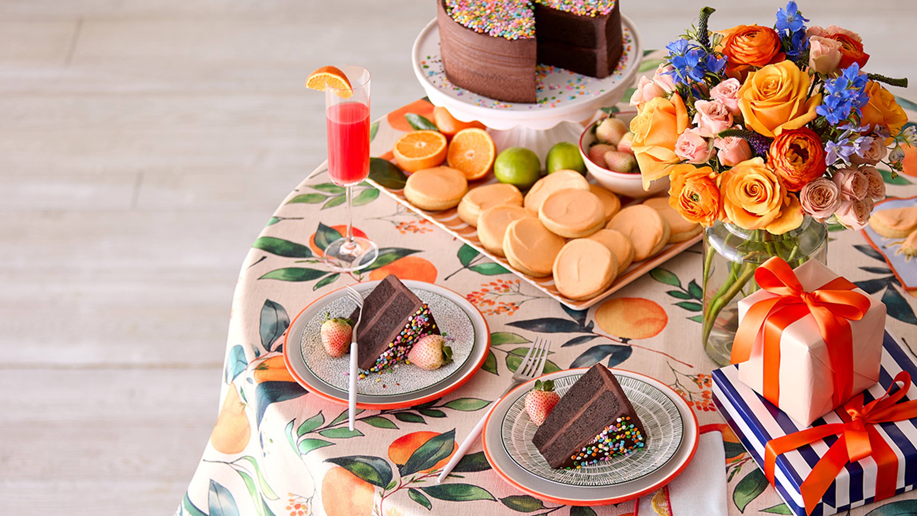 Table with cocktails, cake, and cookies.