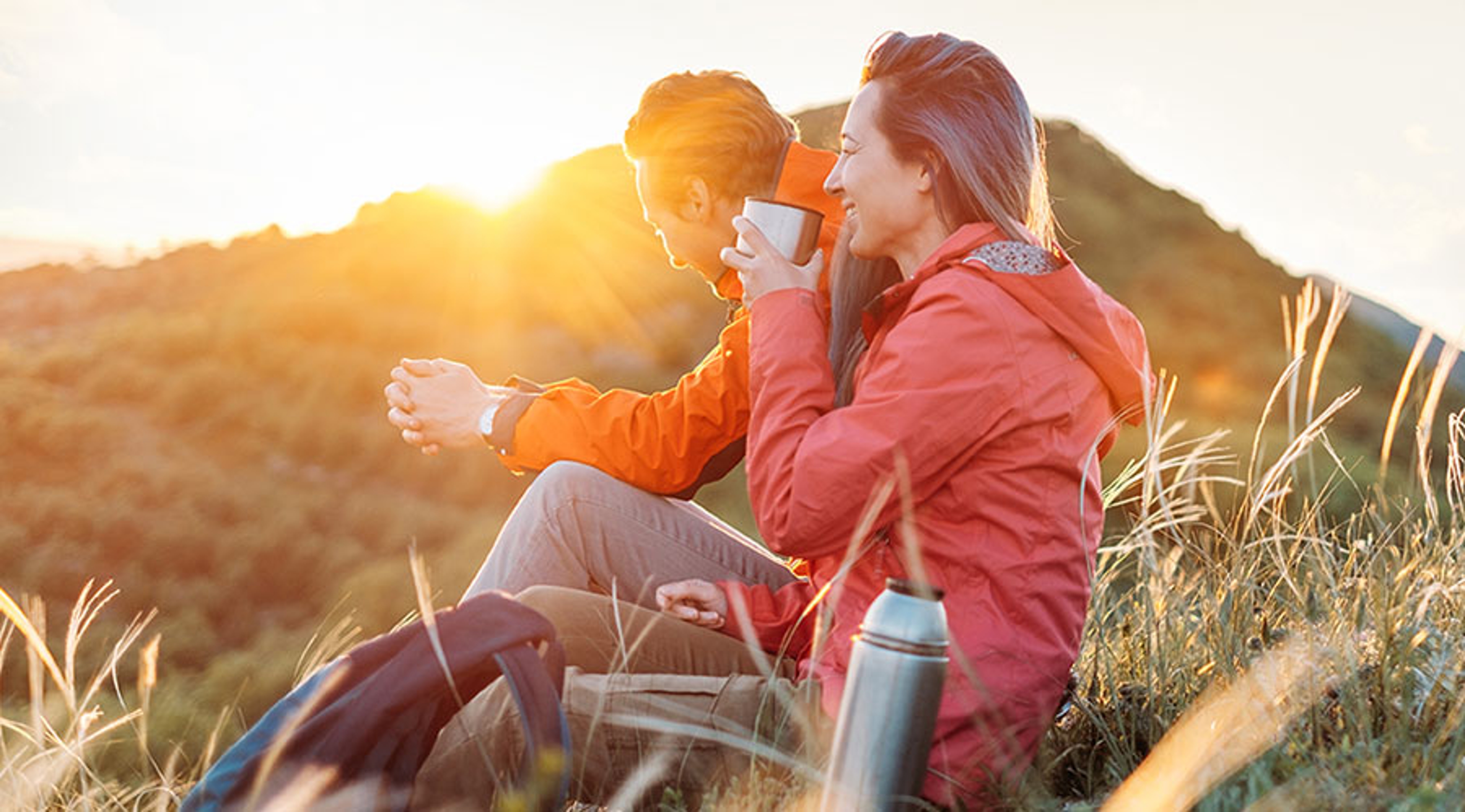 Article Cards Featured Image Two people outdoors on a mountain hiking sitting down drinking coffee