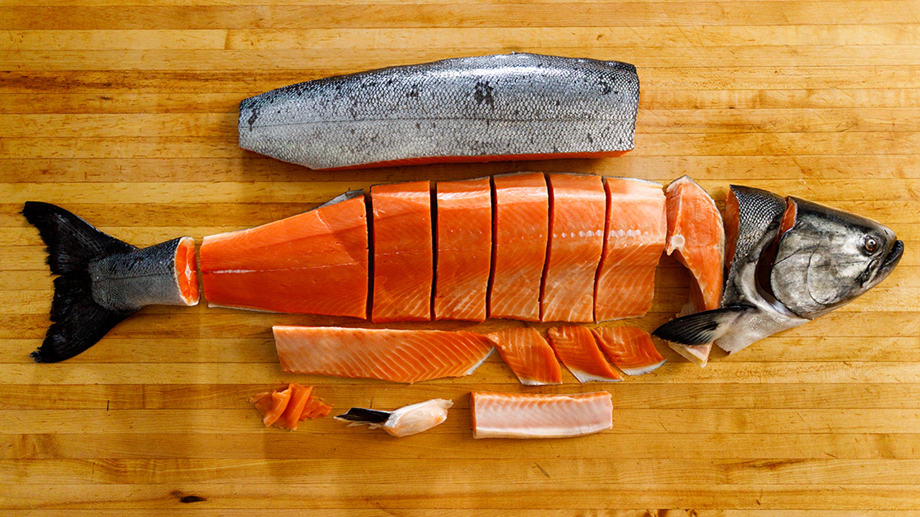 Wild Alaskan King Salmon deconstructed on a wooden board.