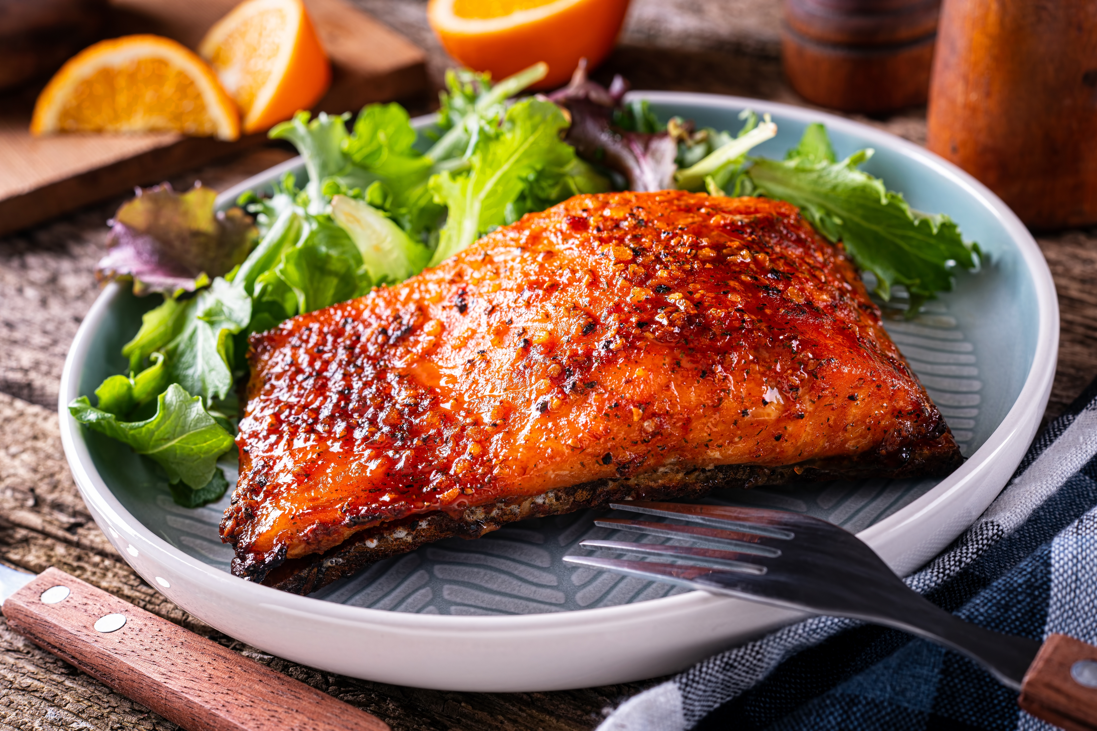 cedar plank grilling salmon fillet on cedar plank on plate with vegetables