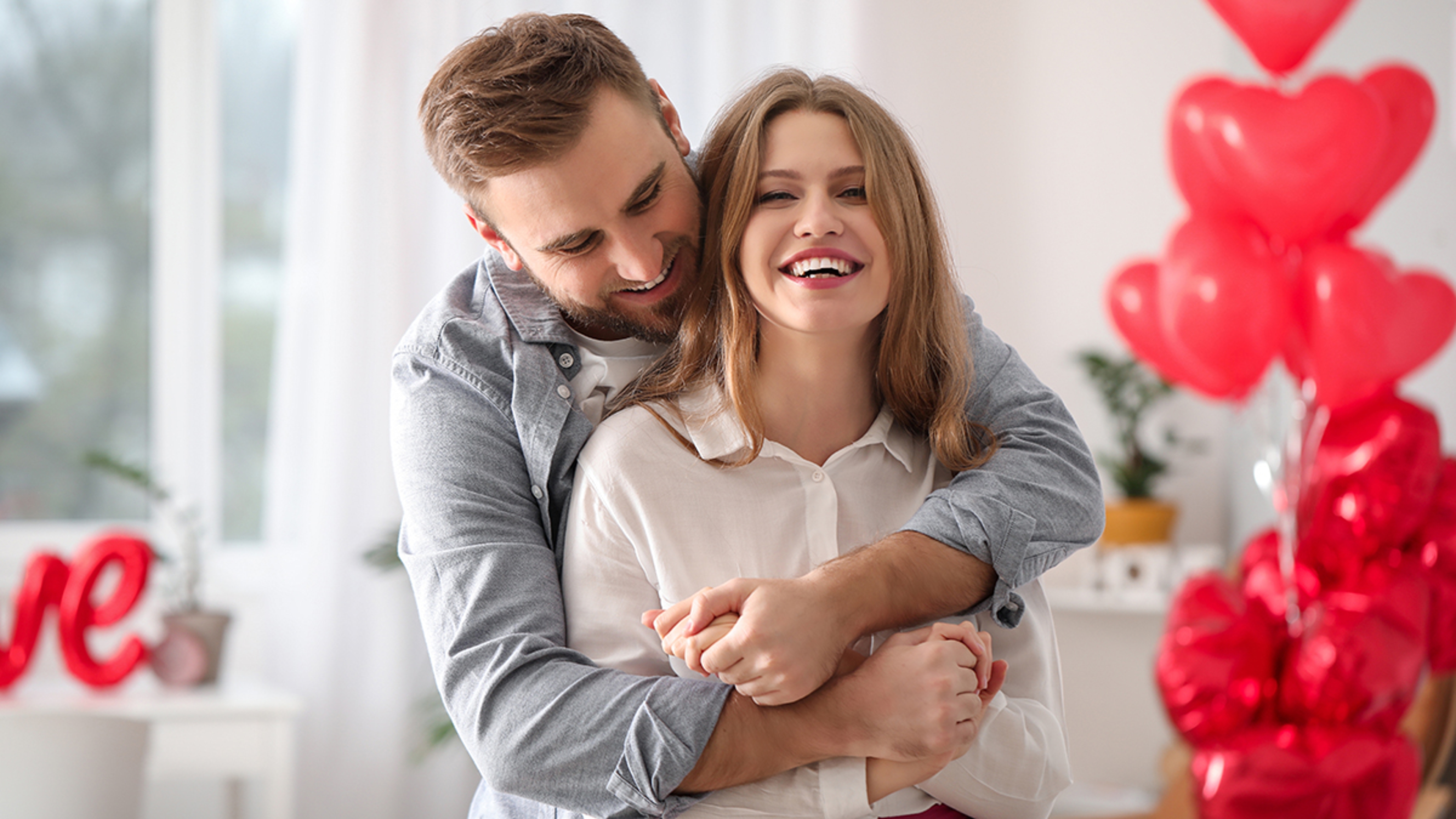 Happy young couple celebrating Valentine's Day at home