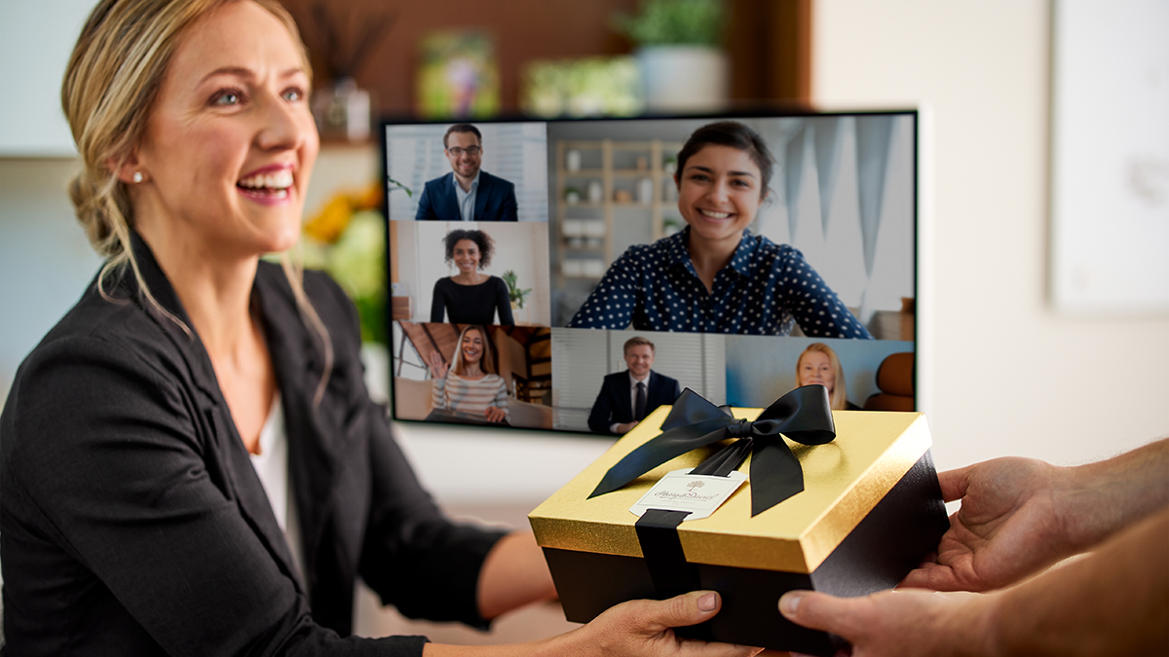 Woman receiving anniversary wishes at her desk while on a zoom call.