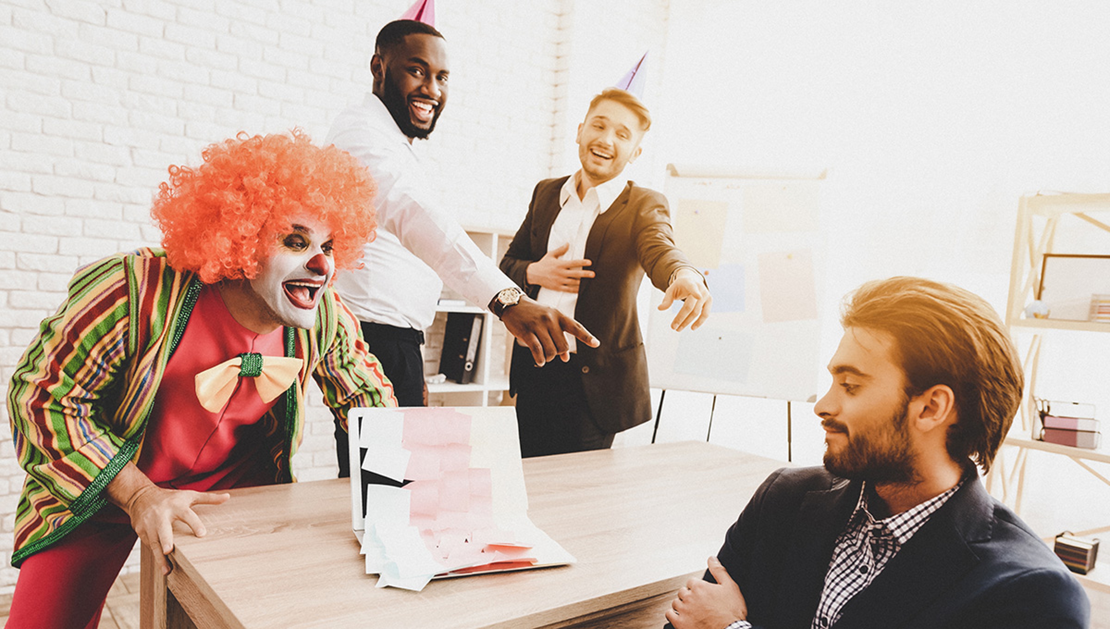 Article Cards Featured Image Young Man in Clown Costume on Meeting in Office.