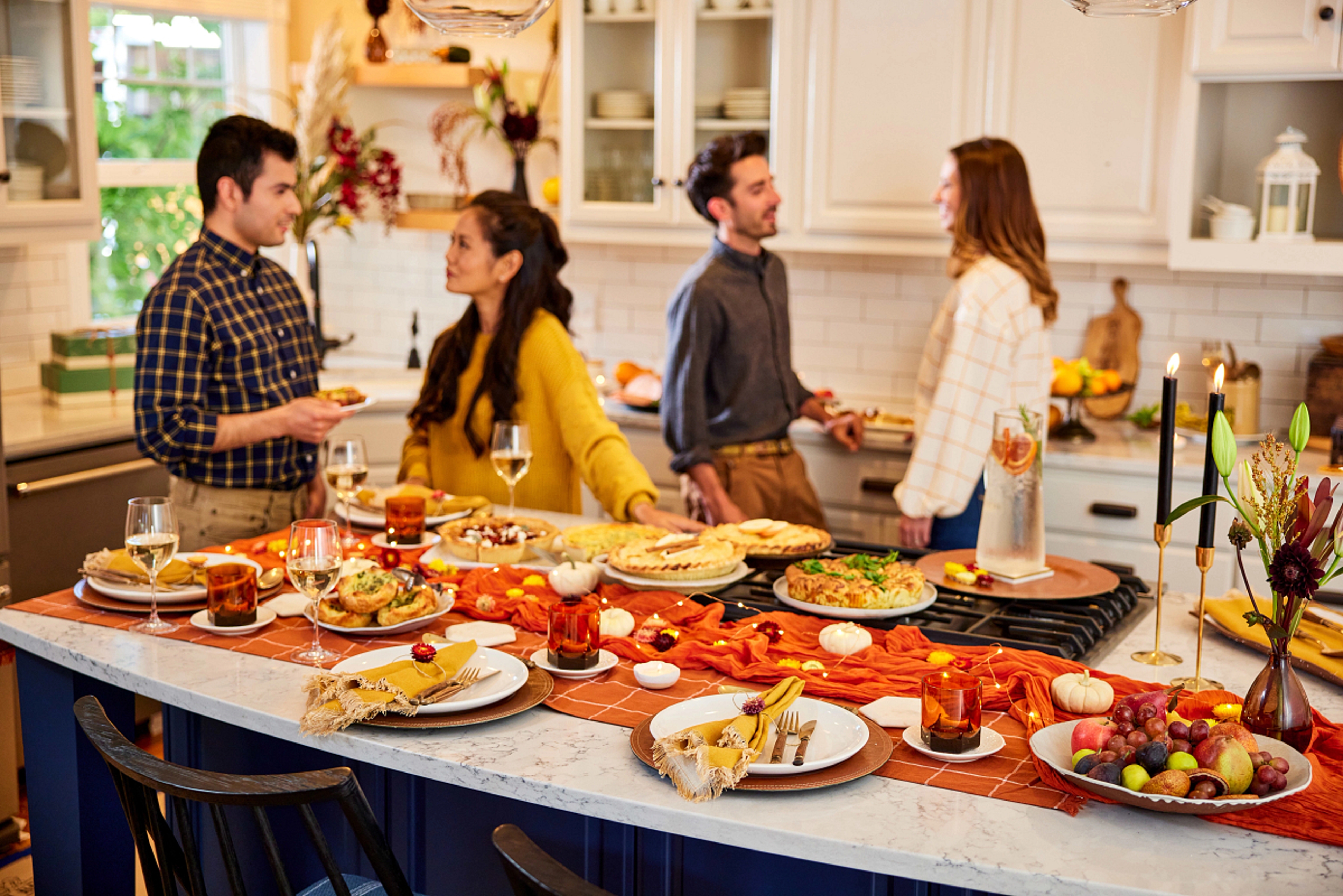 Group adults talking in the kitchen at Thanksgiving.