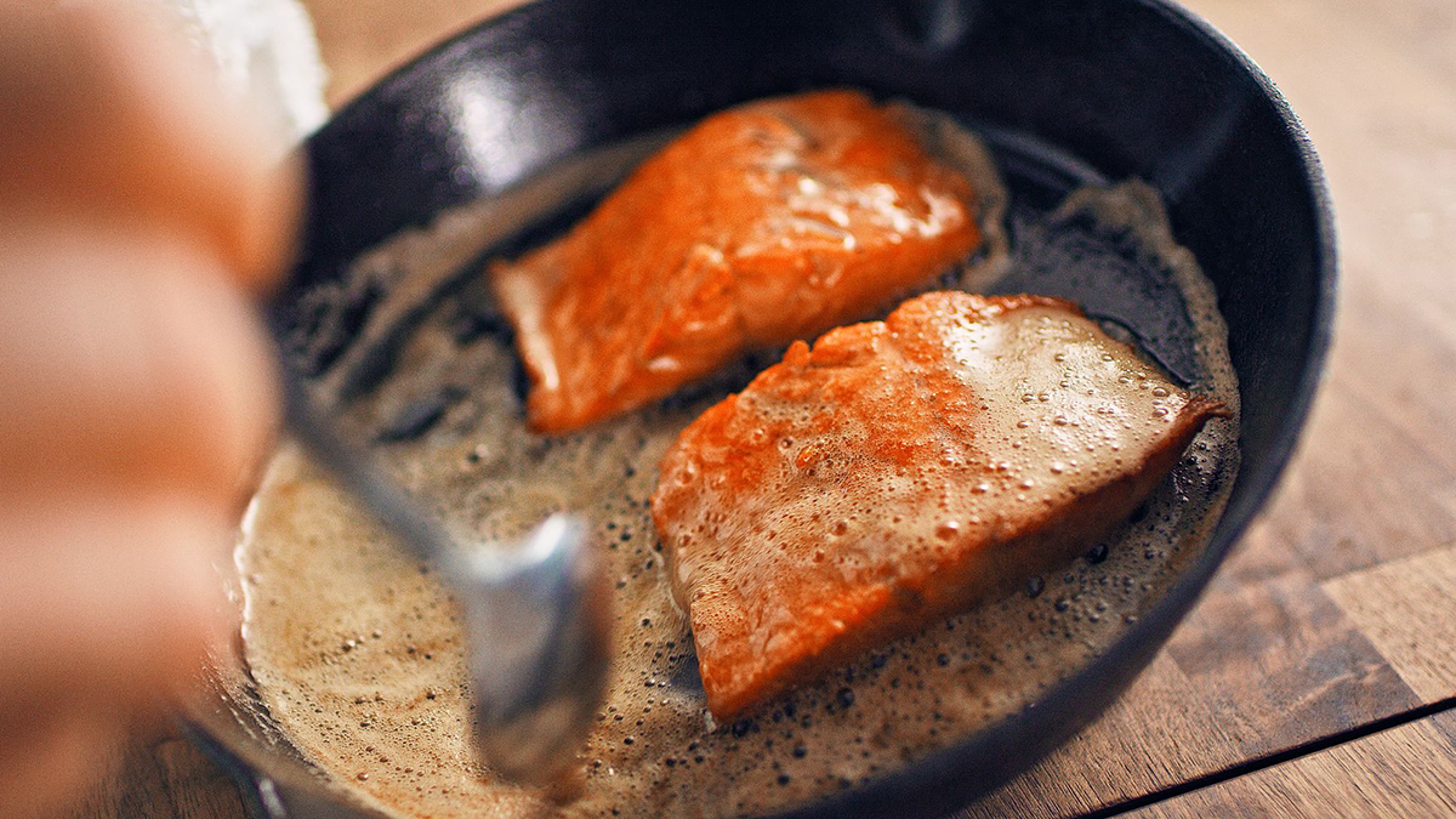 Copper River sockeye salmon filets in a frying pan.