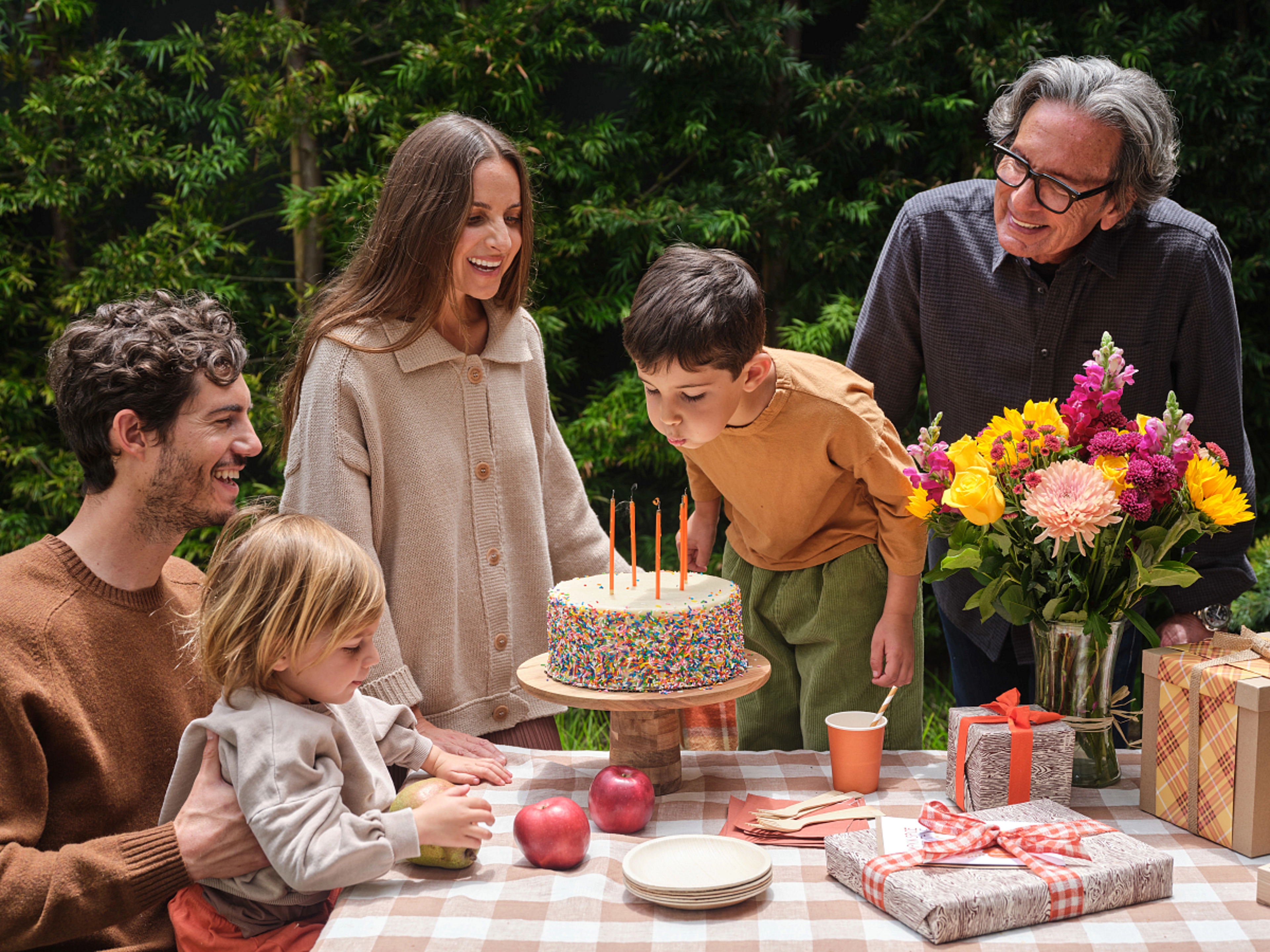 Group of adults and kids celebrating a november birthday outside.