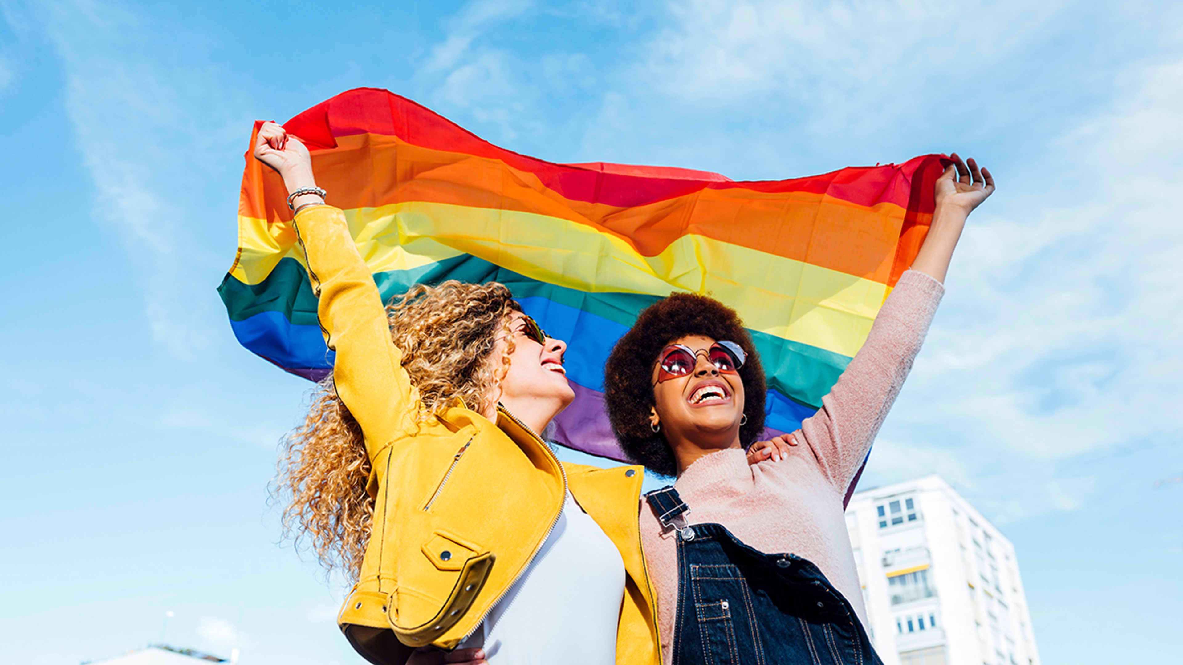 Article Cards Featured Image pride month gifts two women holding pride flag