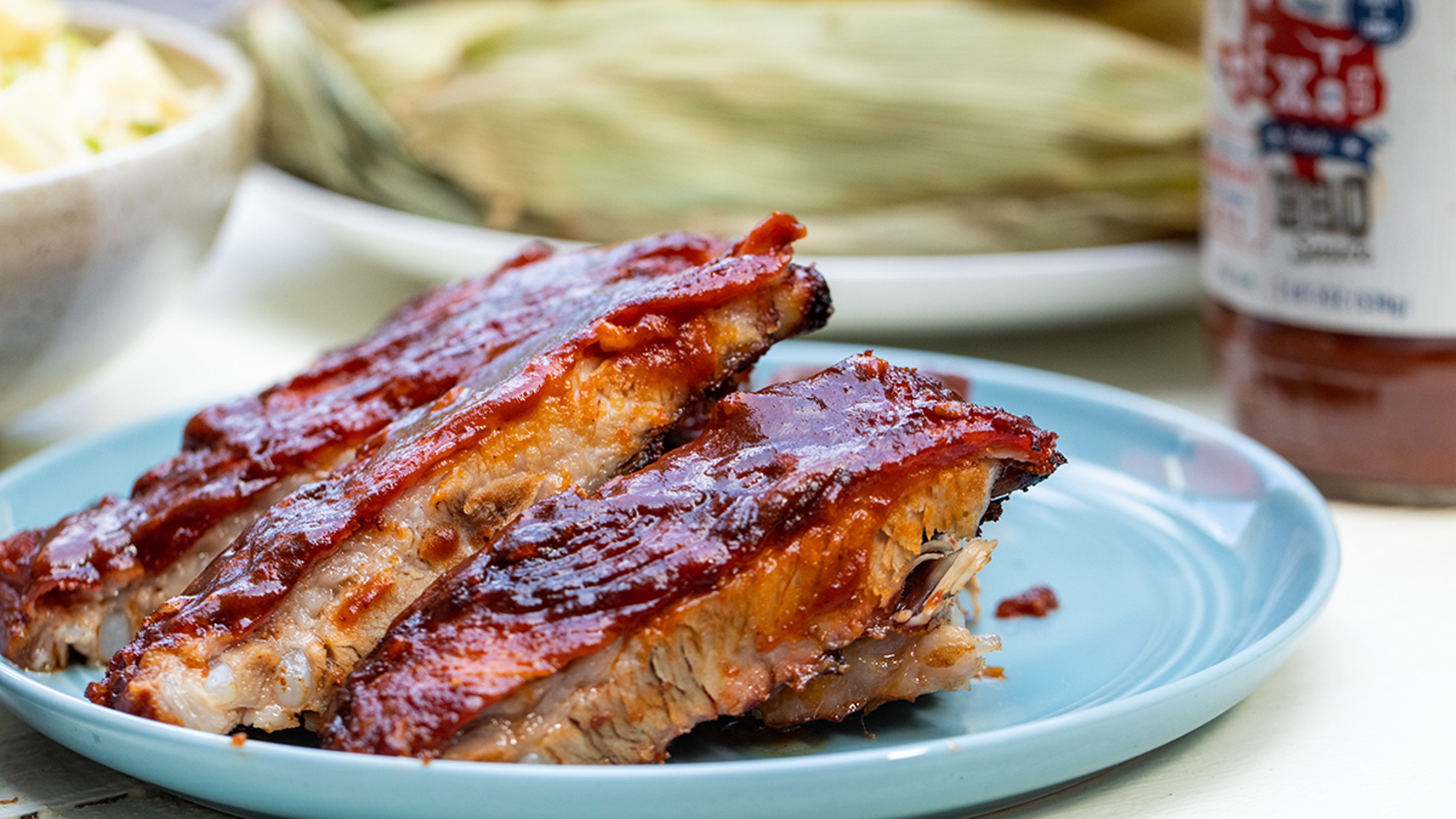 Photo of how to grill with a plate of grilled ribs on a table.