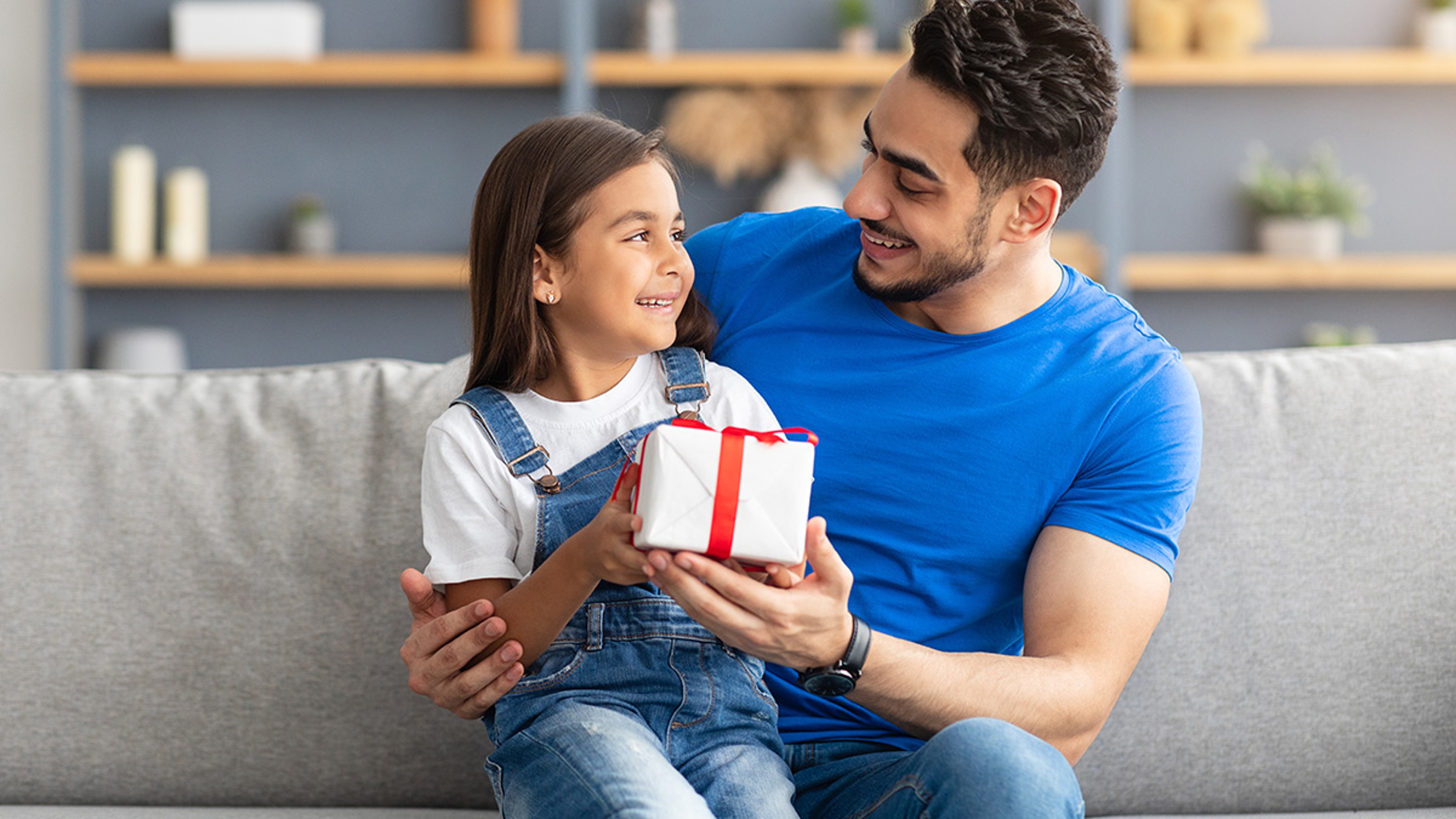 Article Cards Featured Image father giving gift to daughter on International Day of Charity