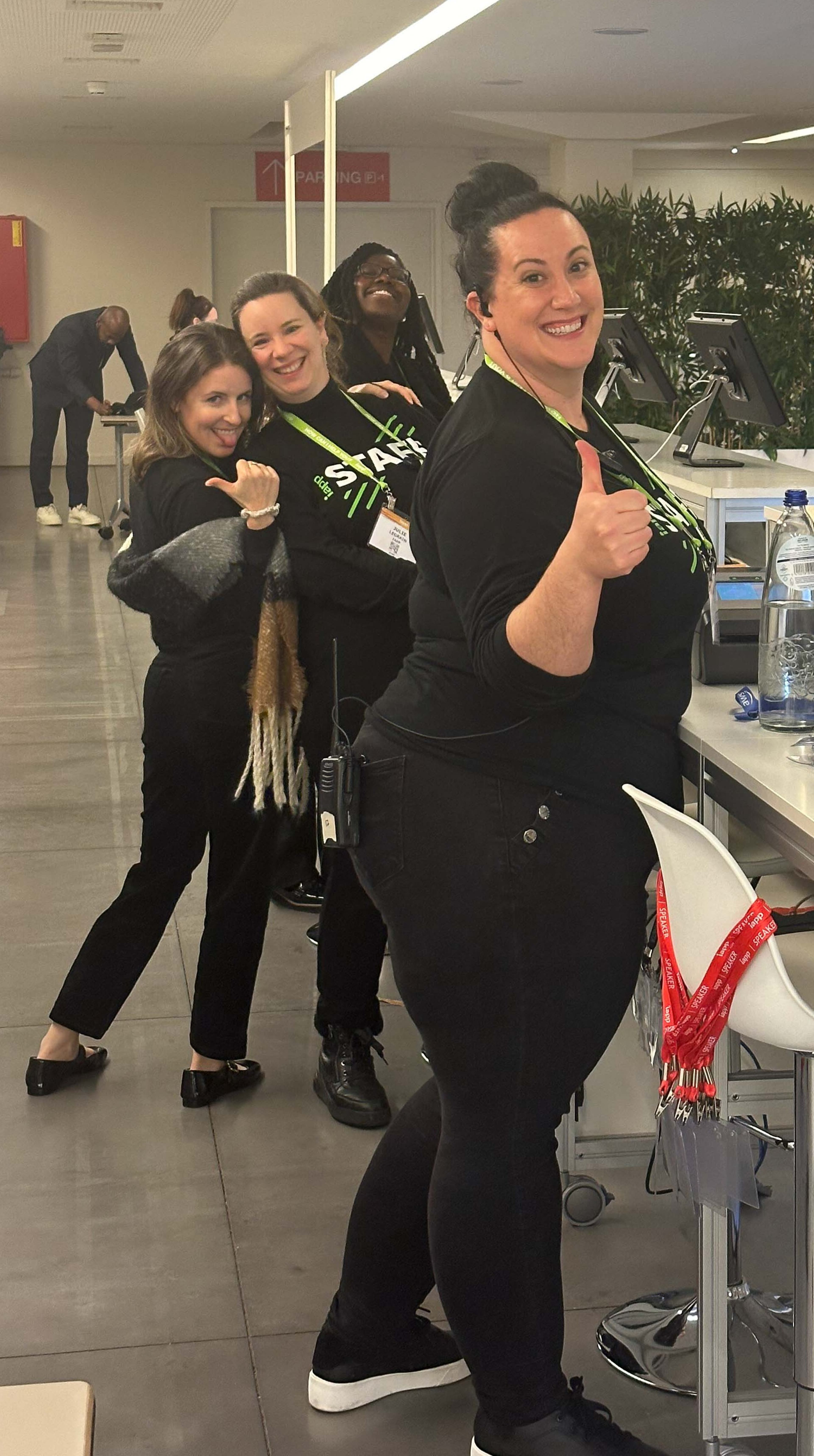 IAPP staff at a conference booth. The woman in the front is smiling and giving a thumbs up to the camera.