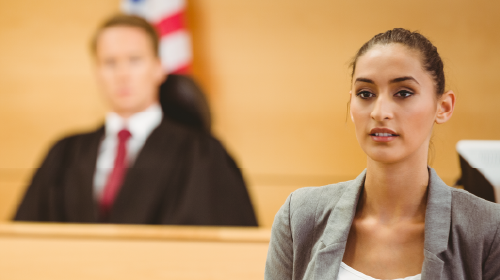 lawyer standing in a courtroom with judge sitting in background