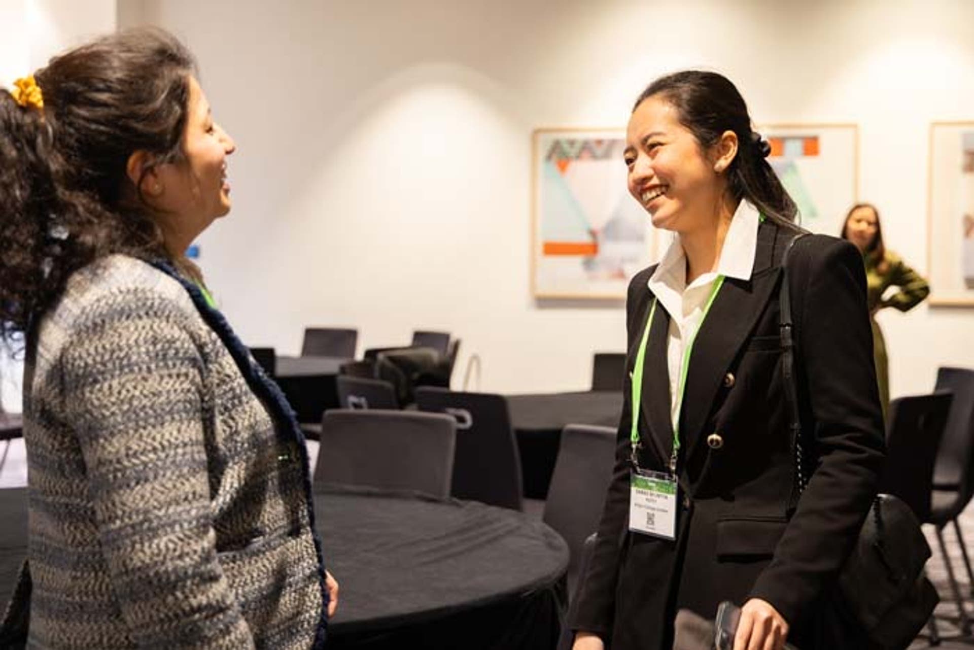 Two women talking with each other at a conference