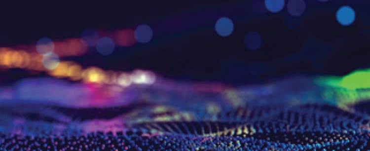 Abstract digital illustration with a mixture of in-focus and out-of-focus dots ranging from deep purple and indigo to pink, orange, and green.