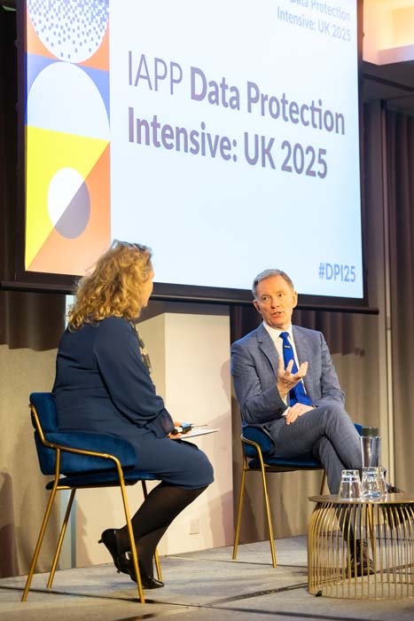 Two people on stage at a conference presentation