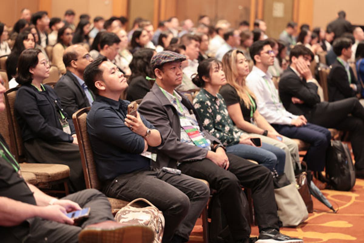 Exhibit hall with attendees walking and talking near booths featuring banners and digital screens promoting privacy and AI governance solutions.