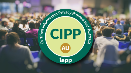 A green circular IAPP certification badge reading Certified Information Privacy Professional/Australia with the acronym CIPP/AU in the center, displayed over a blurred background of conference attendees seated in a large audience.