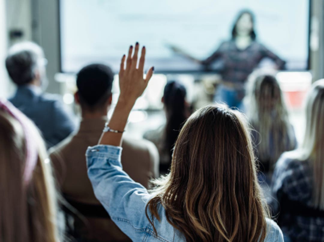 woman raising hand in live-taught class