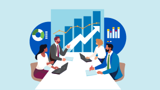 Four people at a table with laptops discussing in front of a large upward-trending chart.