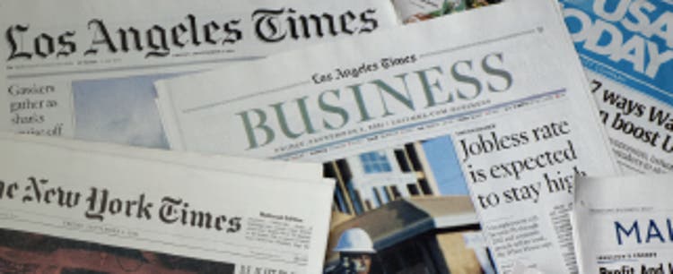 A variety of U.S.-based newspapers casually layered over one another, including the Los Angeles Times, USA Today, and The New York Times.