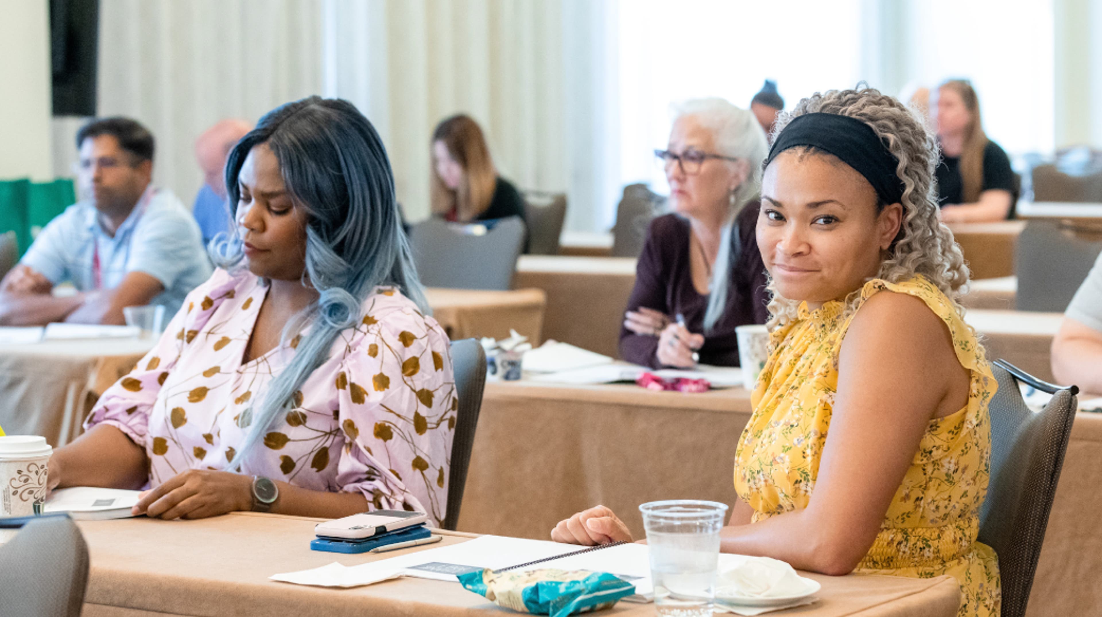 Instructor stands and speaks while students sit and face instructor