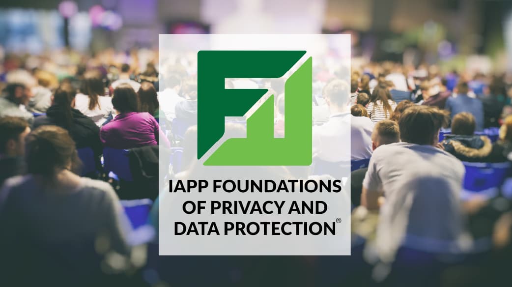 Centered IAPP Foundations of Privacy and Data Protection logo placed over a blurred conference scene with a large audience seated in rows of blue chairs. The background shows a crowded lecture hall with attendees facing a brightly lit stage area, creating a sense of depth and activity. The logo is prominent in the foreground, featuring a green geometric design above the course title in bold black text.