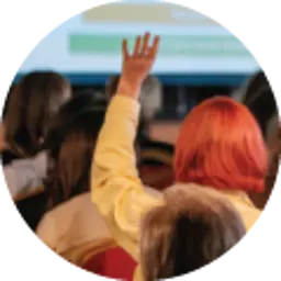 Image of a woman with pink hair raising her hand in front of a presentation