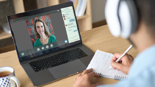 person at desk engaging in live online training on their laptop