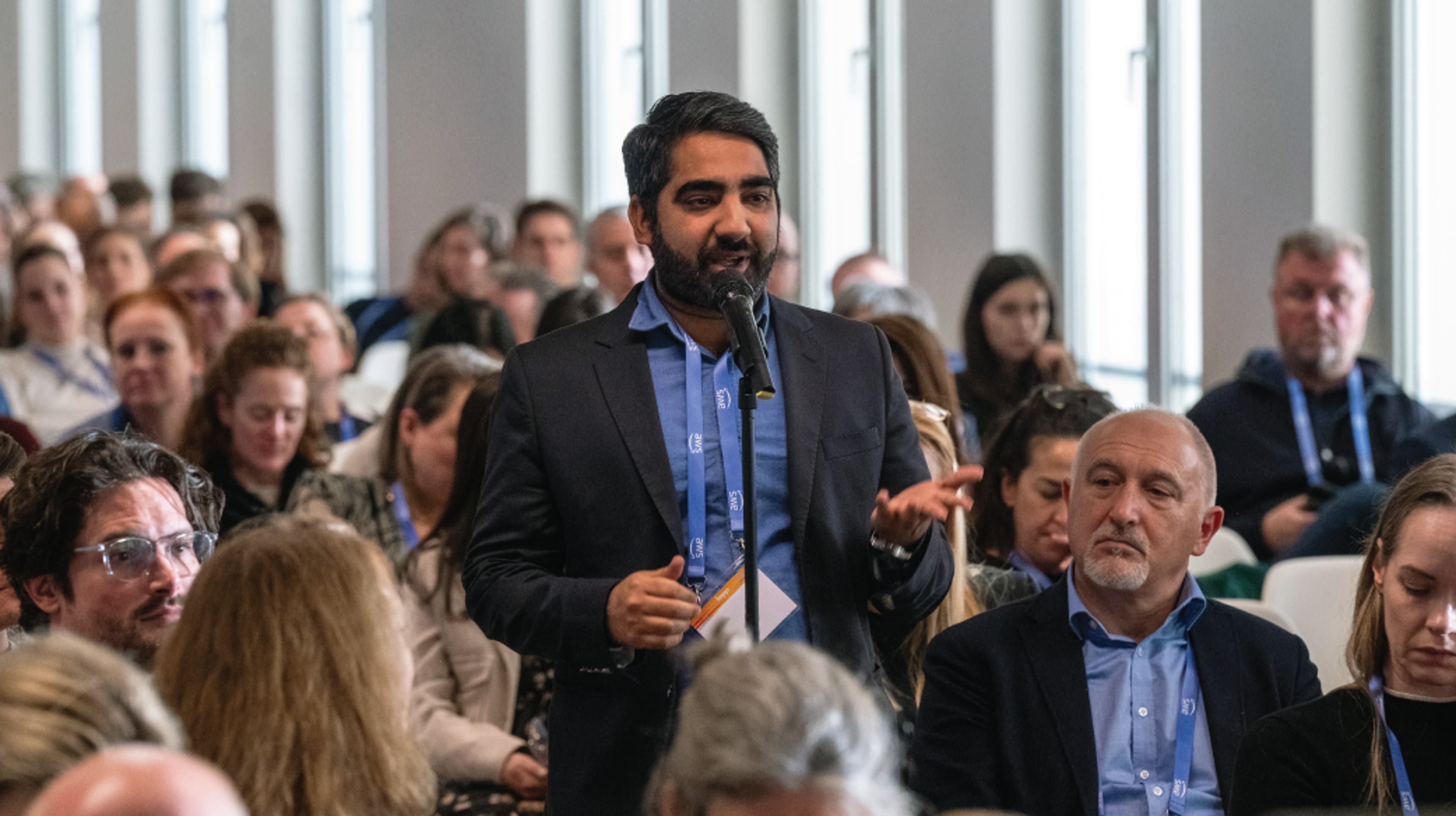 an audience looking at a speaker on stage