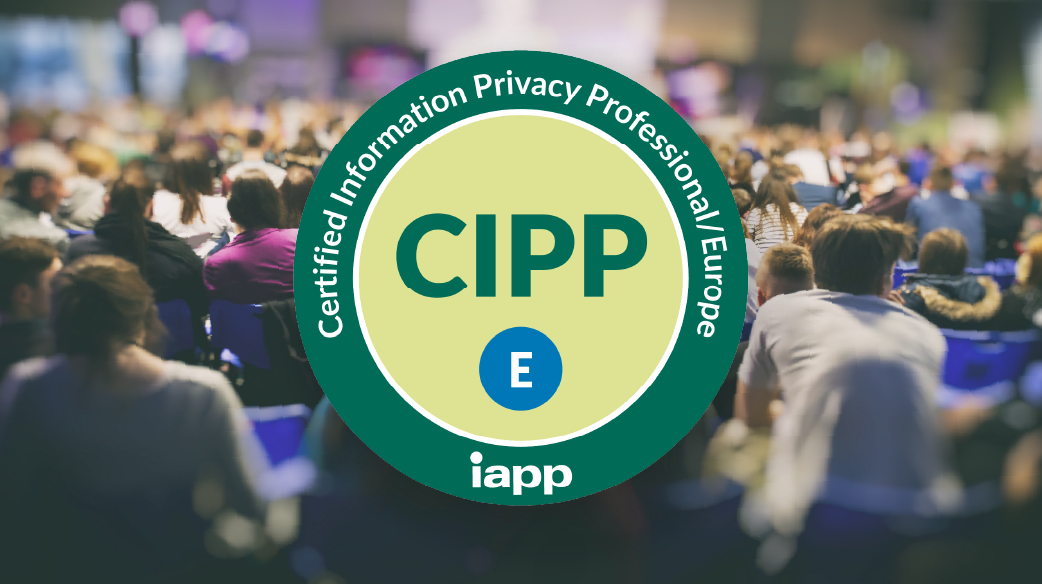 Large green and light yellow circular badge with the text “Certified Information Privacy Professional Europe” and the IAPP logo around the edge. “CIPP” in bold letters and an E in a blue circle located in the center of the badge. The badge is overlaid on a blurred background of a crowded conference audience seated in rows.
