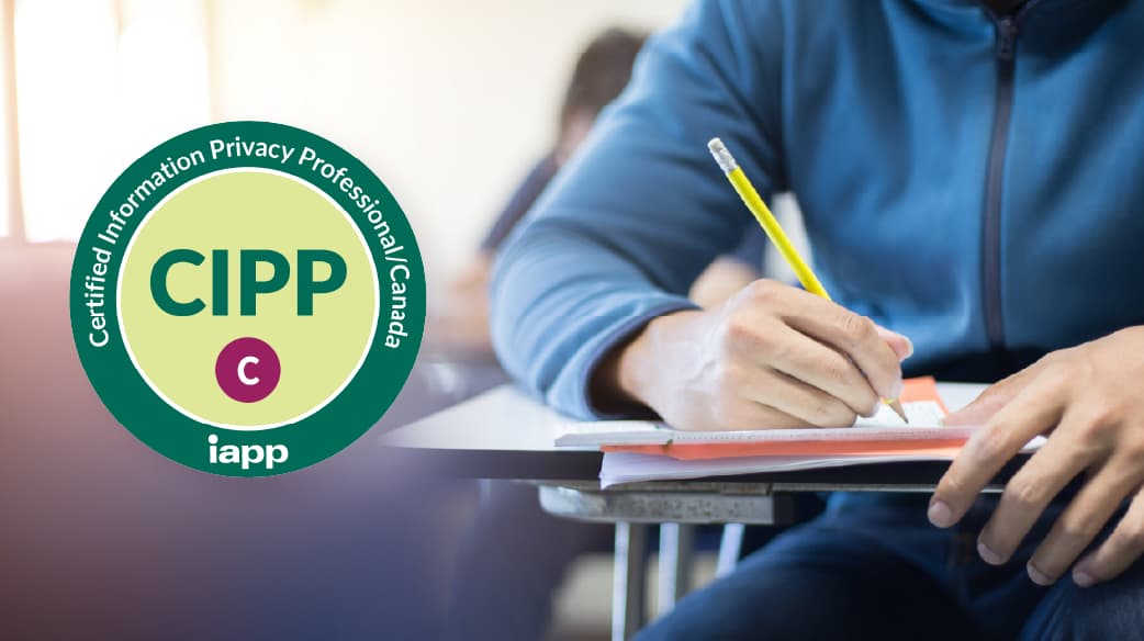 Close-up of a person writing in a notebook with a yellow pencil at a classroom desk. On the left side of the image is a circular green badge with the text “Certified Information Privacy Professional/Canada” around the edge, “CIPP/C” in the center, and the IAPP logo at the bottom.