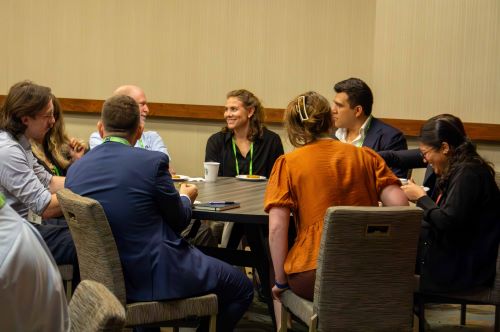 A group of people sitting around a table talking at a Privacy Bar section meetup
