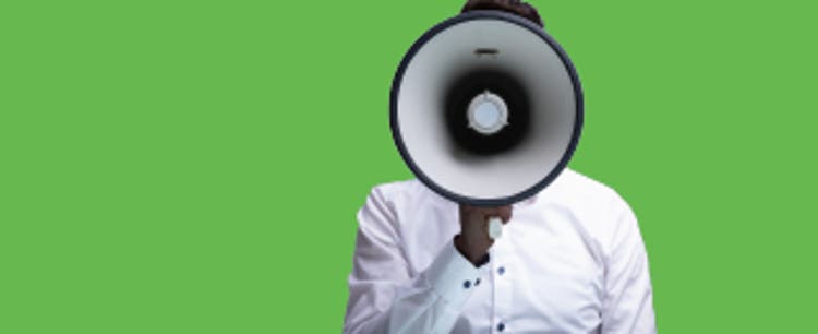 A person wearing a crisp, white button-down shirt holds a megaphone over their face, obscuring all but the very top of their head.