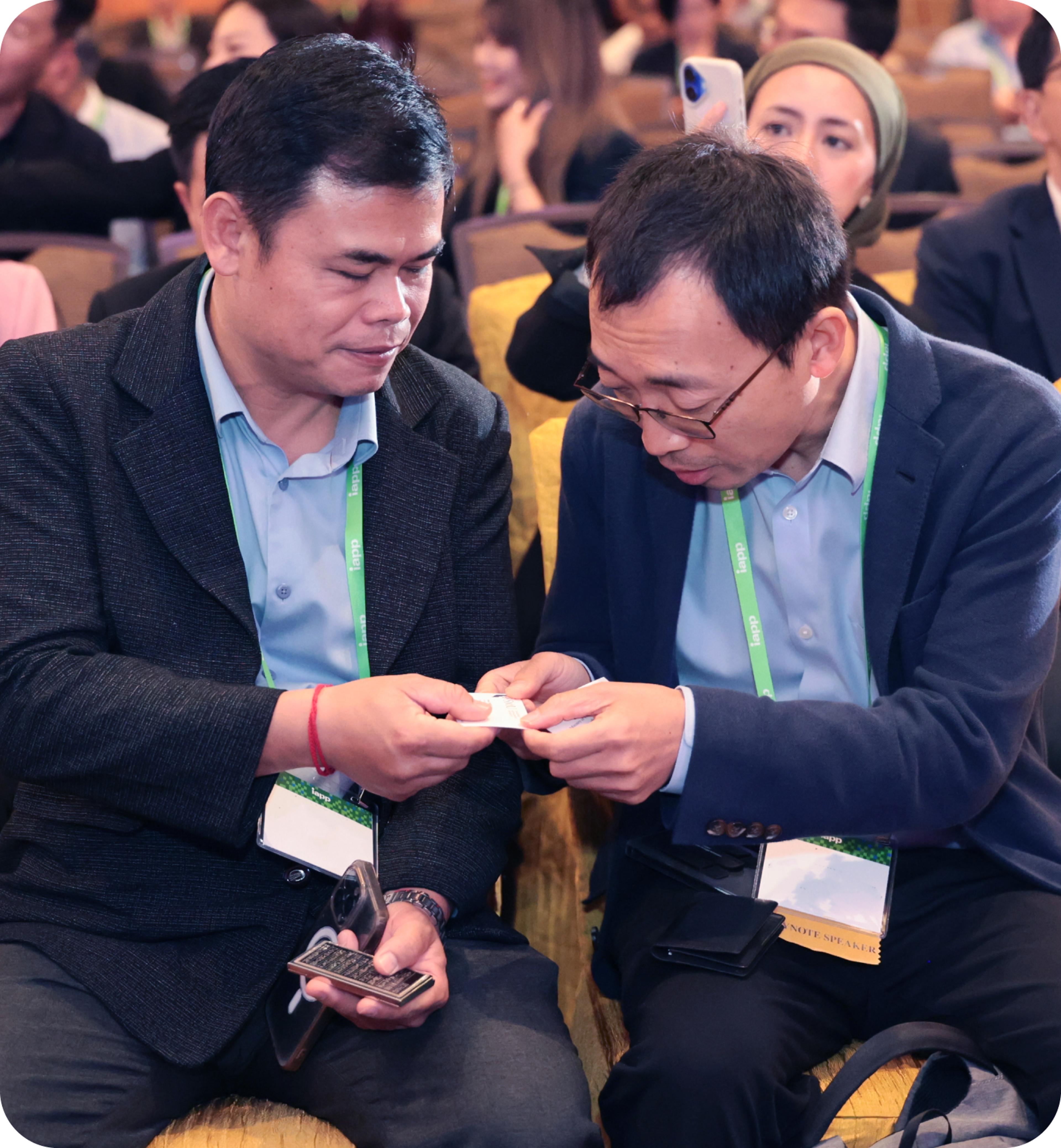 Two men at a conference exchanging business cards