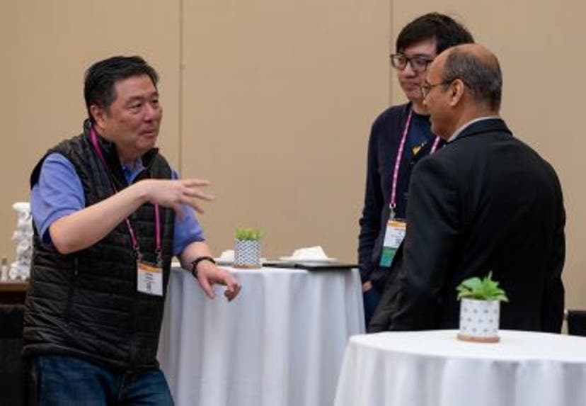 A group of three men speaking to each other at a Diversity in Privacy section meetup