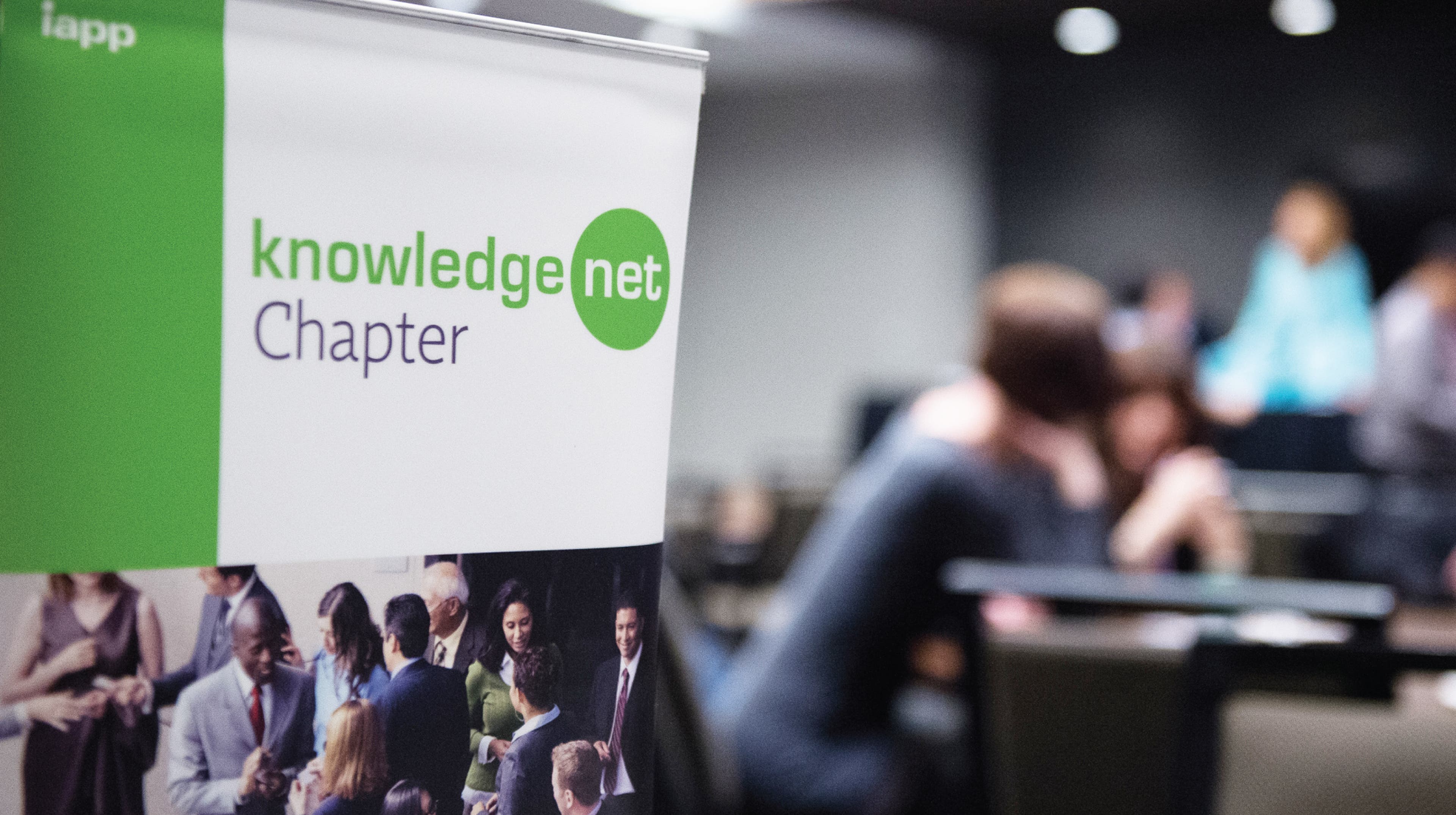 a group of four people discussing while at a table with open books