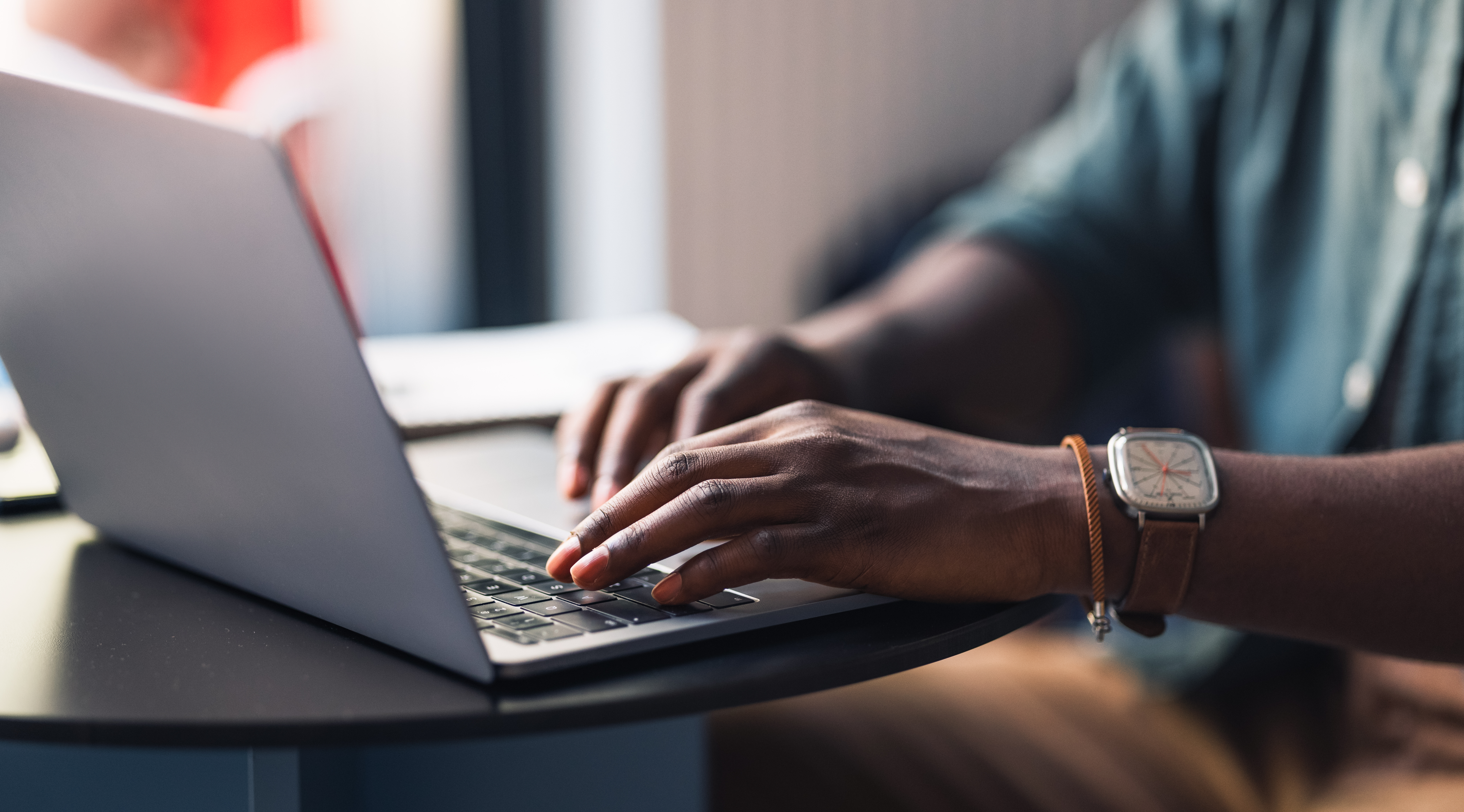 Hands typing on a laptop computer.