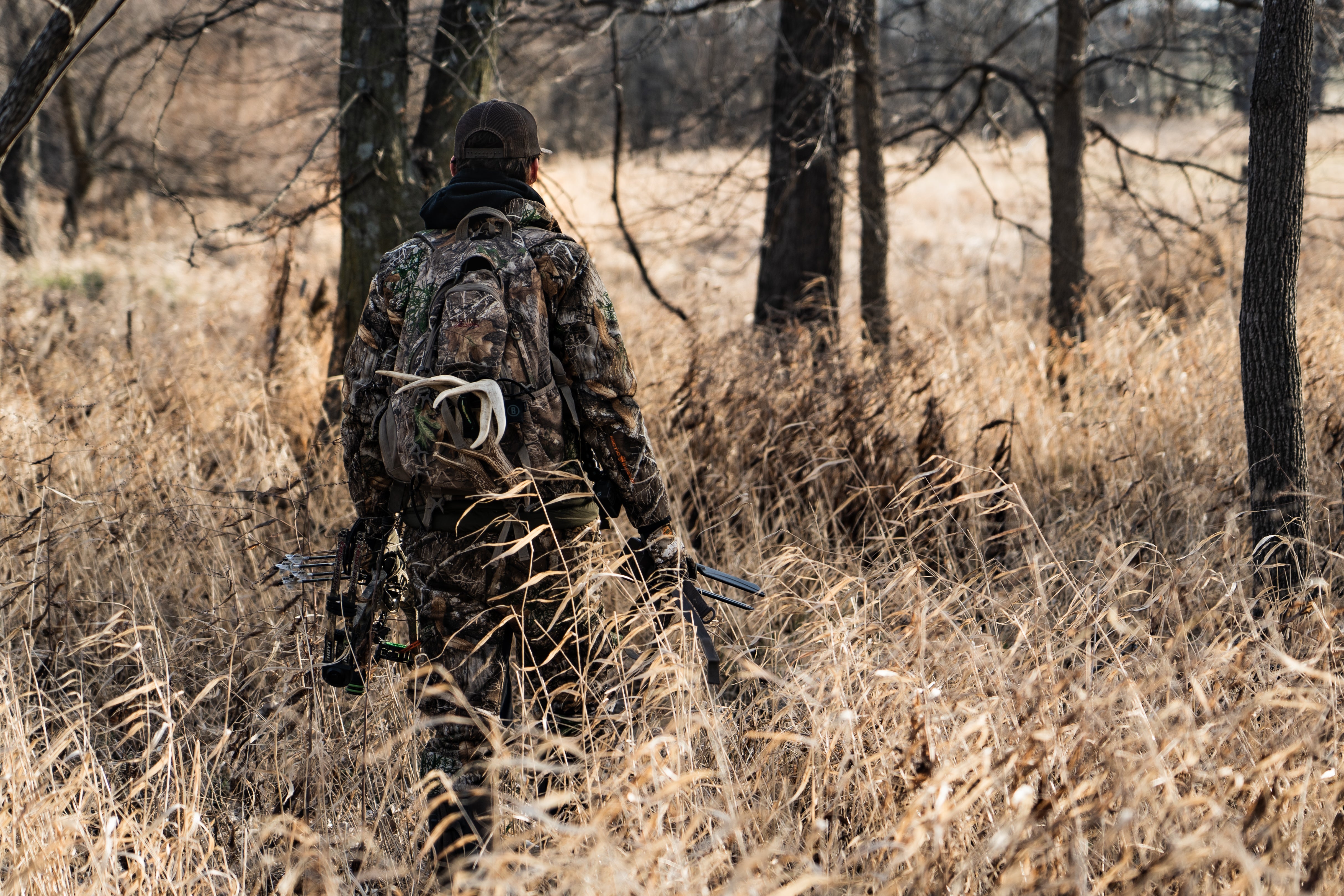 Hunter walking into field with deer stand