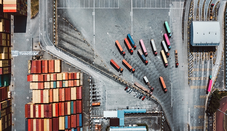 aerial view of a shipping yard with shipping containers and tractor trailers