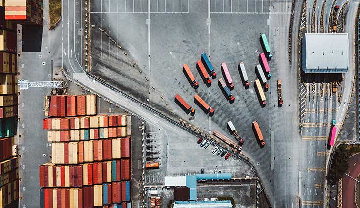 aerial view of a shipping yard with shipping containers and tractor trailers