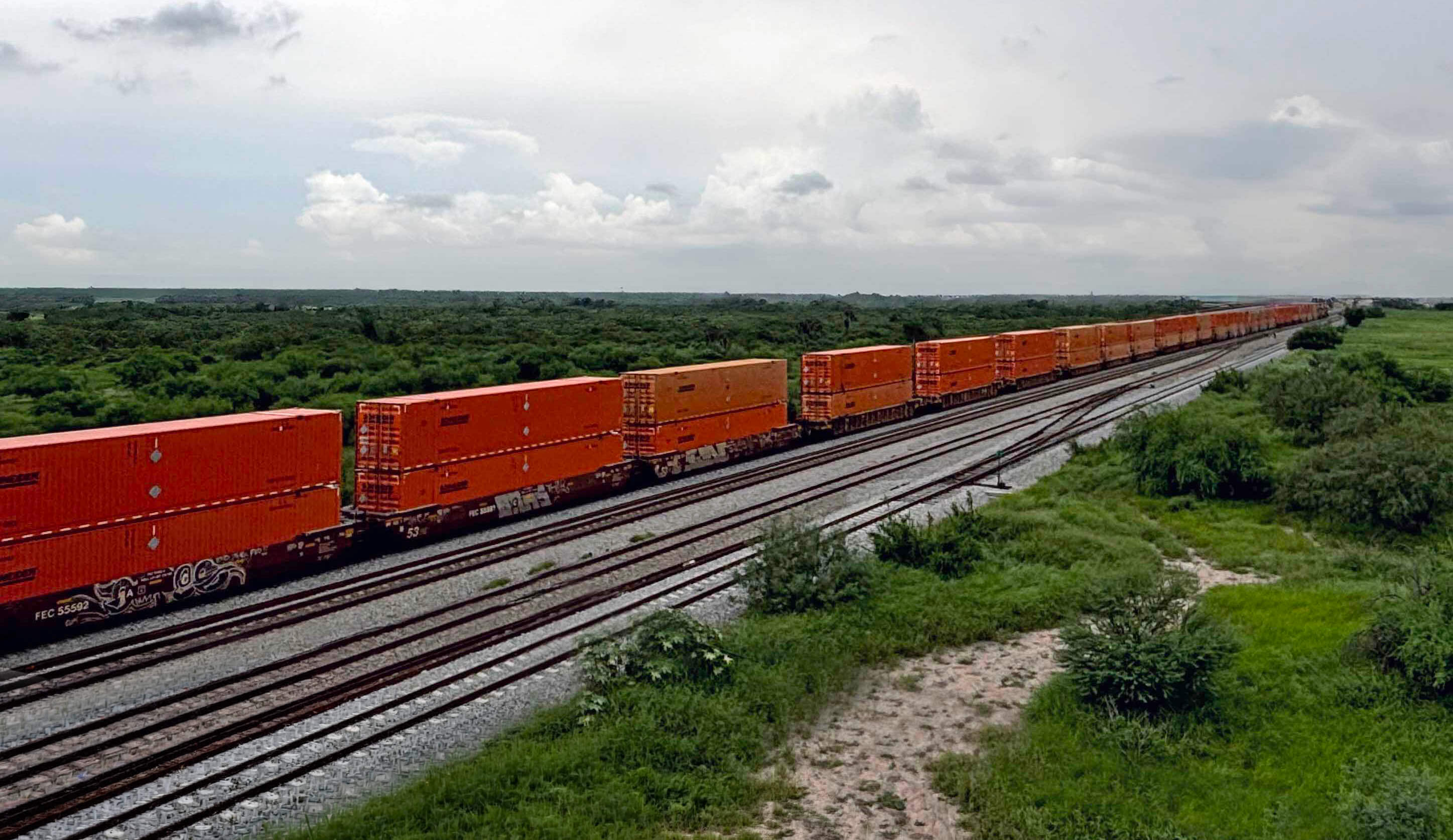 A long line of double stacked Schneider containers on the railroad