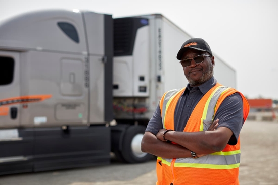 Refrigerated truck company driver standing in front of reefer truck