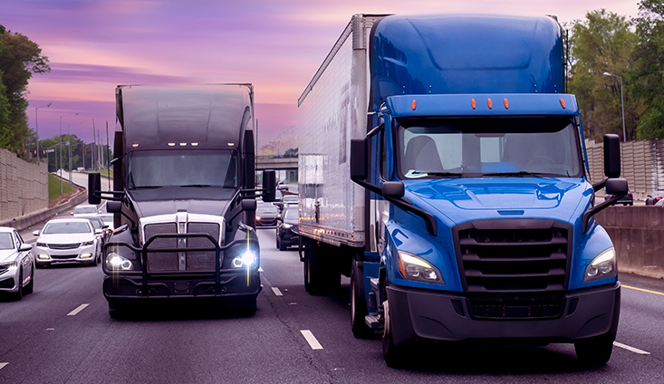 two semi-trucks stopped in traffic on the highway