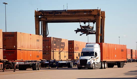 Schneider truck hauling a container in an Intermodal rail yard