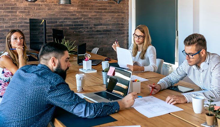 four supply chain professionals strategizing at a table