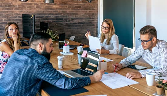 maintaining performance through disruption_hero.jpg four supply chain professionals strategizing at a table