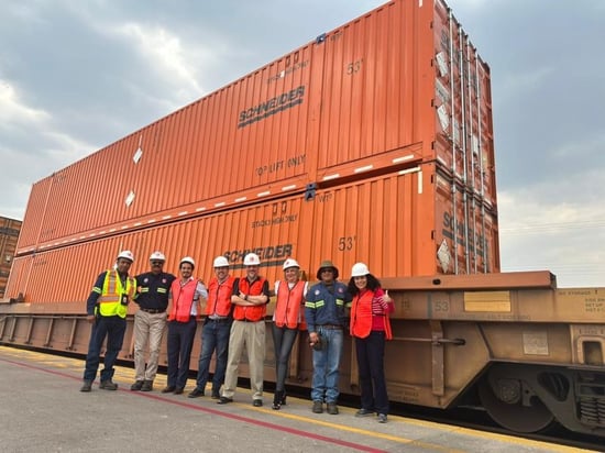 Schneider and CPKC teams together with a double-stacked Schneider Intermodal container