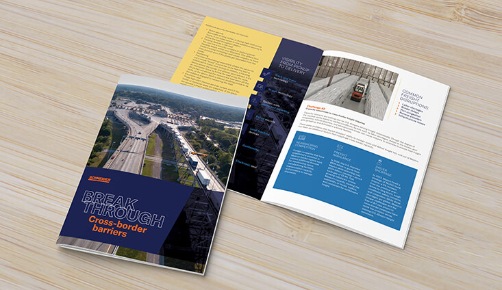 cross border brochure opened up on light wood surface