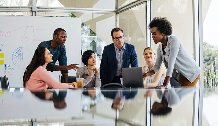 six diverse professionals strategizing around a table